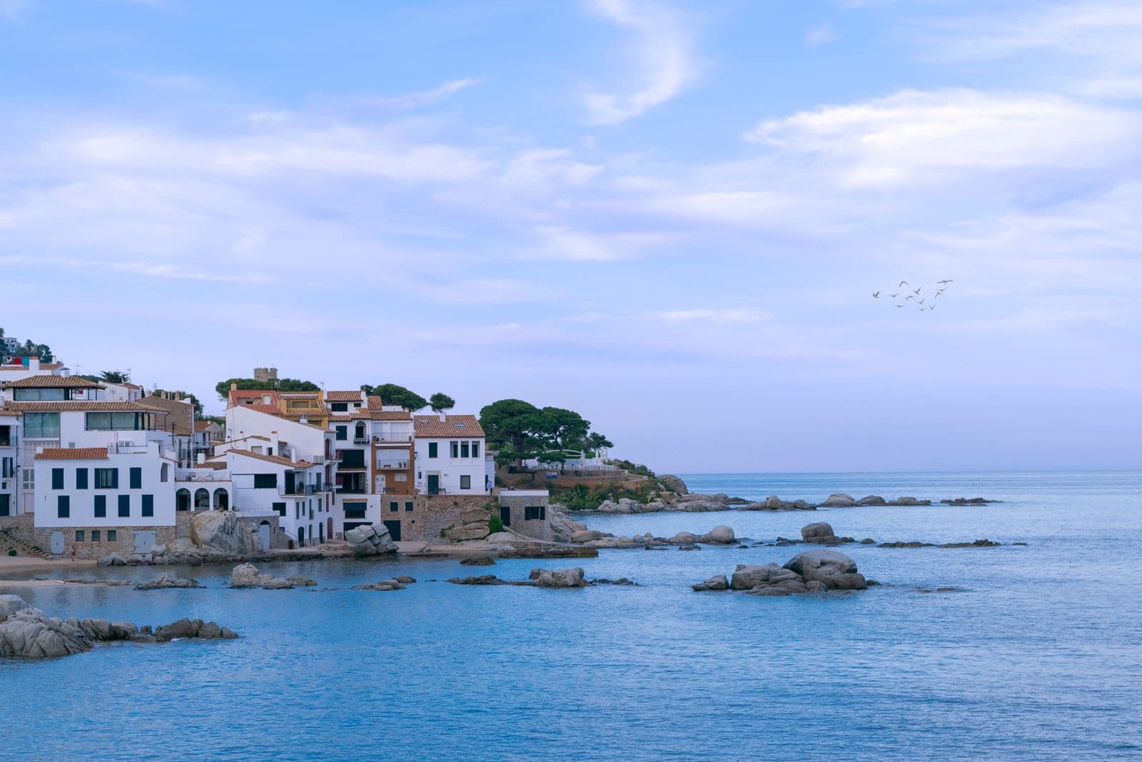 White houses over a turquoise cove on the Costa Brava