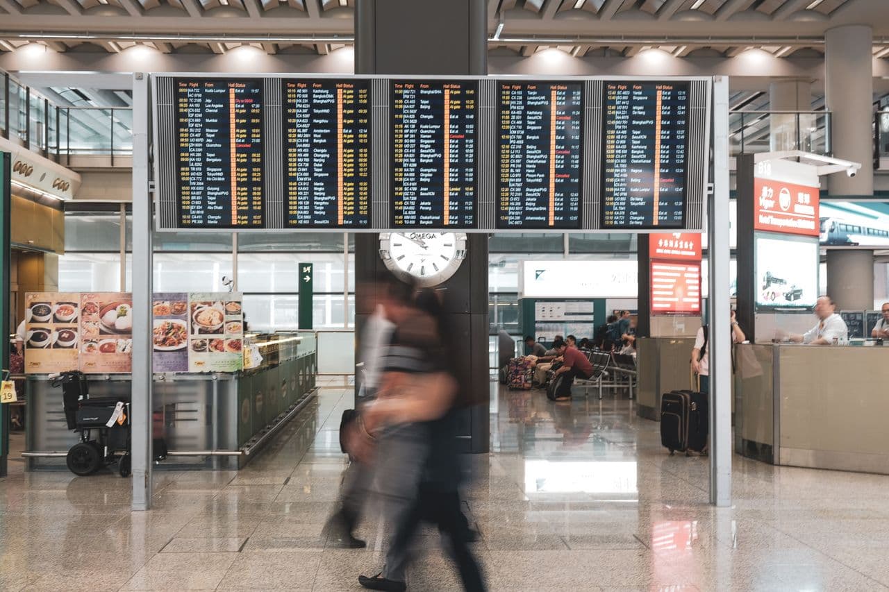 An older couple with suitcases in an airport departure hall