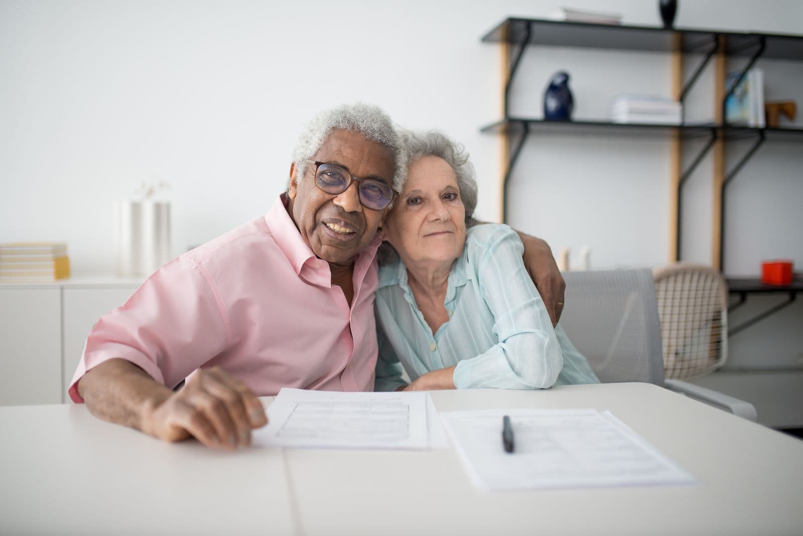 An older couple going through paperwork at their kitchen table
