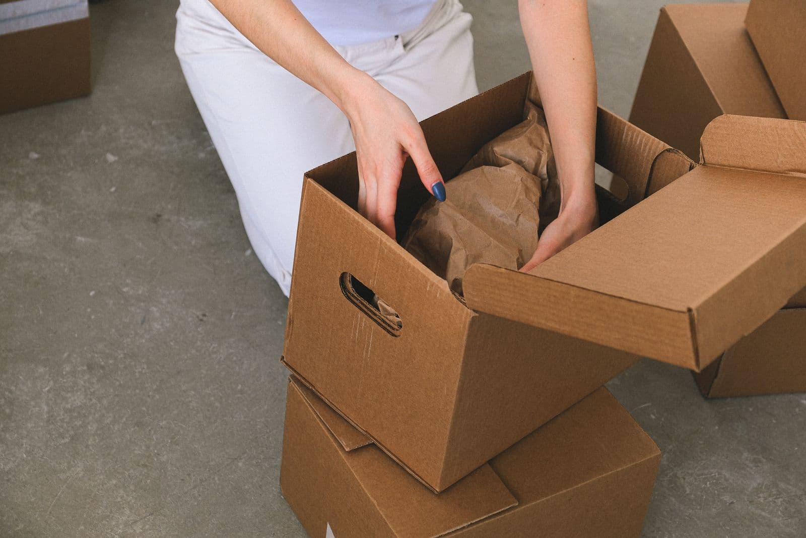 Moving boxes being packed in a half-empty living room