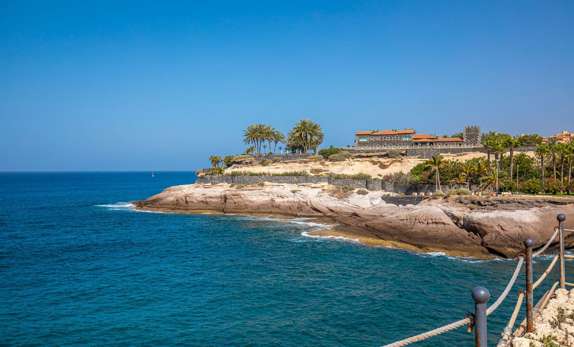 Sonnige Küste mit Palmen und blauem Meer – typisches Winterbild der Kanarischen Inseln/Costa del Sol.